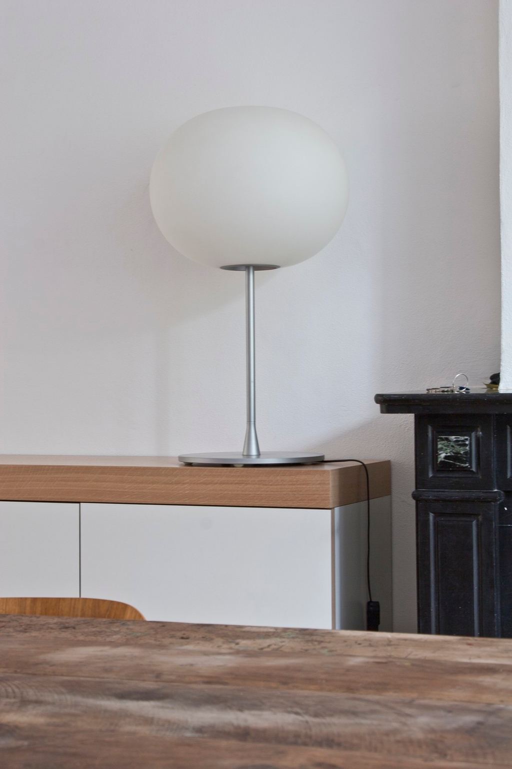 Bollamp op het eiken bovenblad van het lage dressoir.