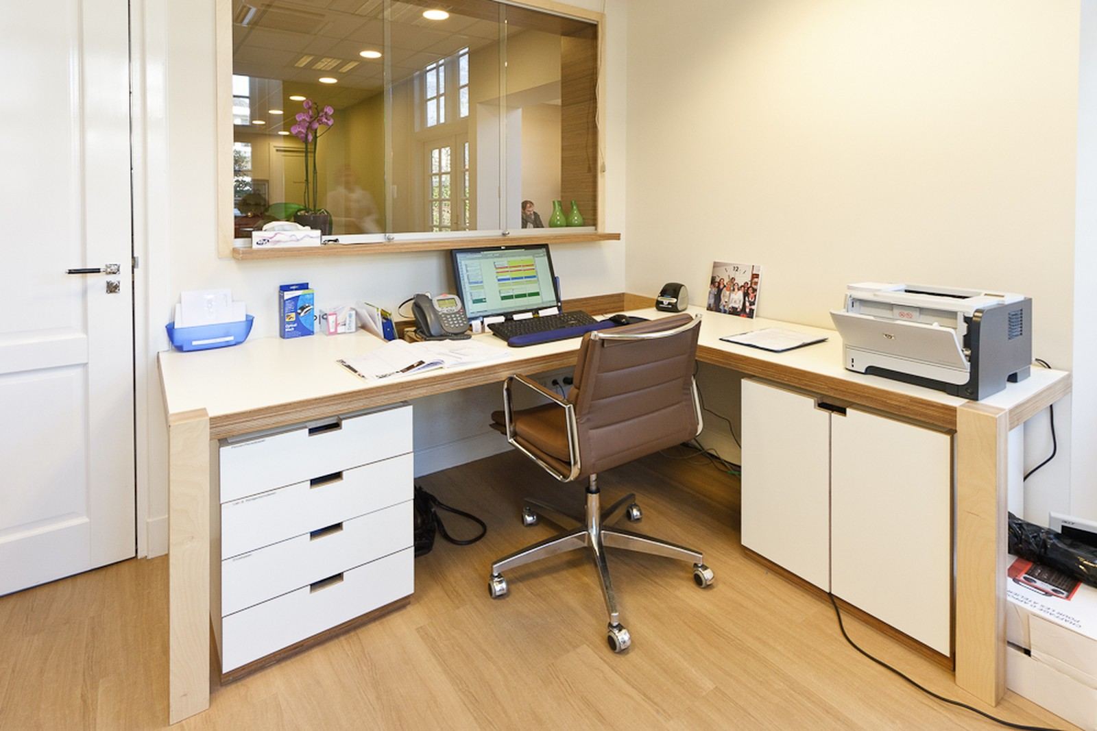 Bureau met ladekast en een wengé werkblad, onder een glazen doorkijk.