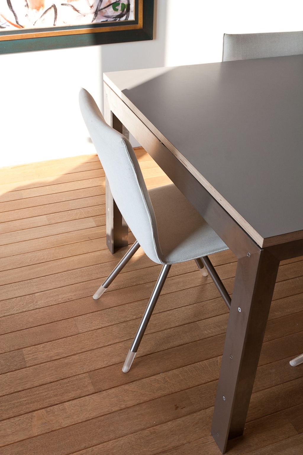 Close-up van de plywood rand en stalen poot van de tafel.