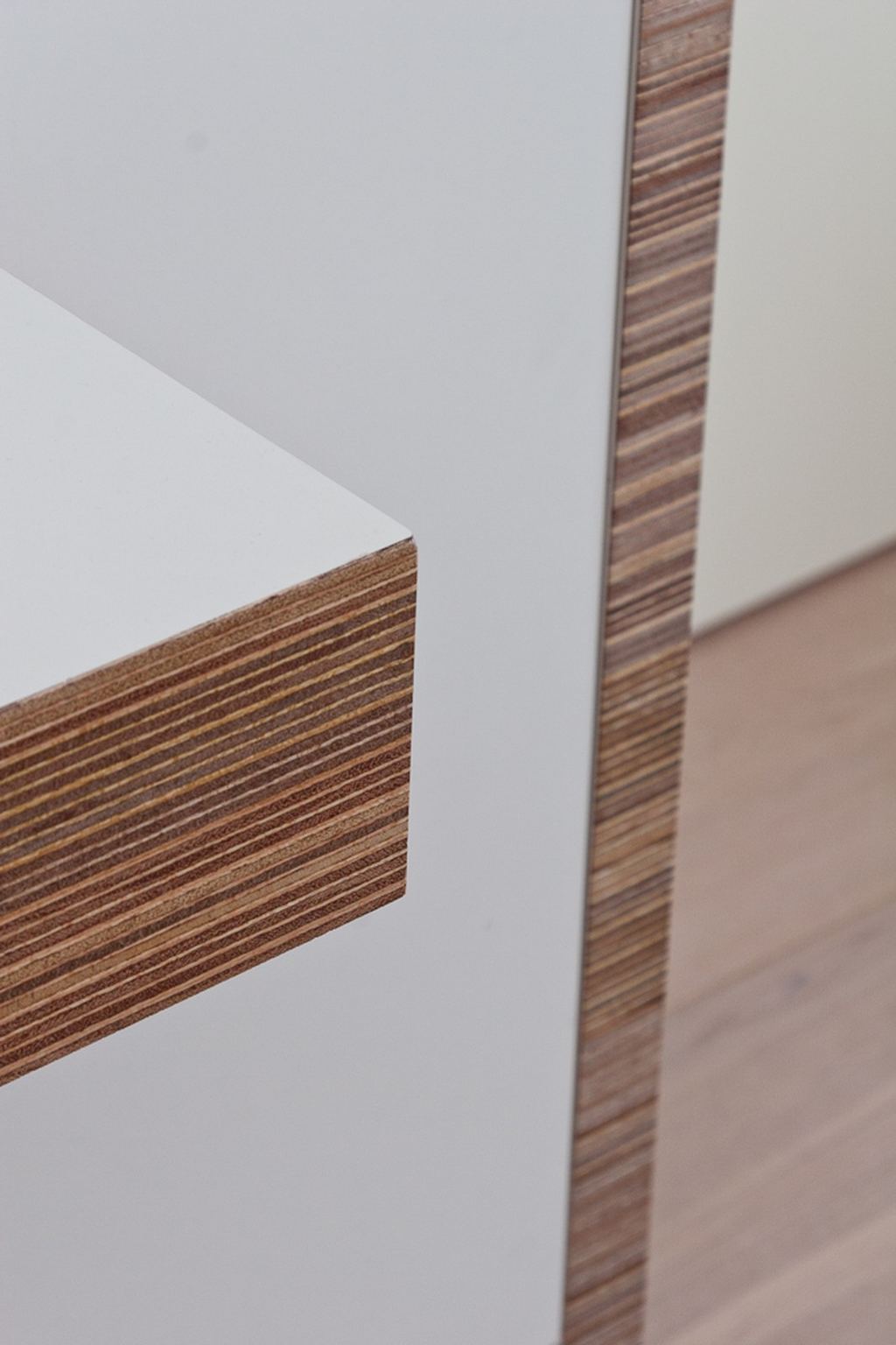 Detail van de plexwood rand van het zwevende bureaublad.