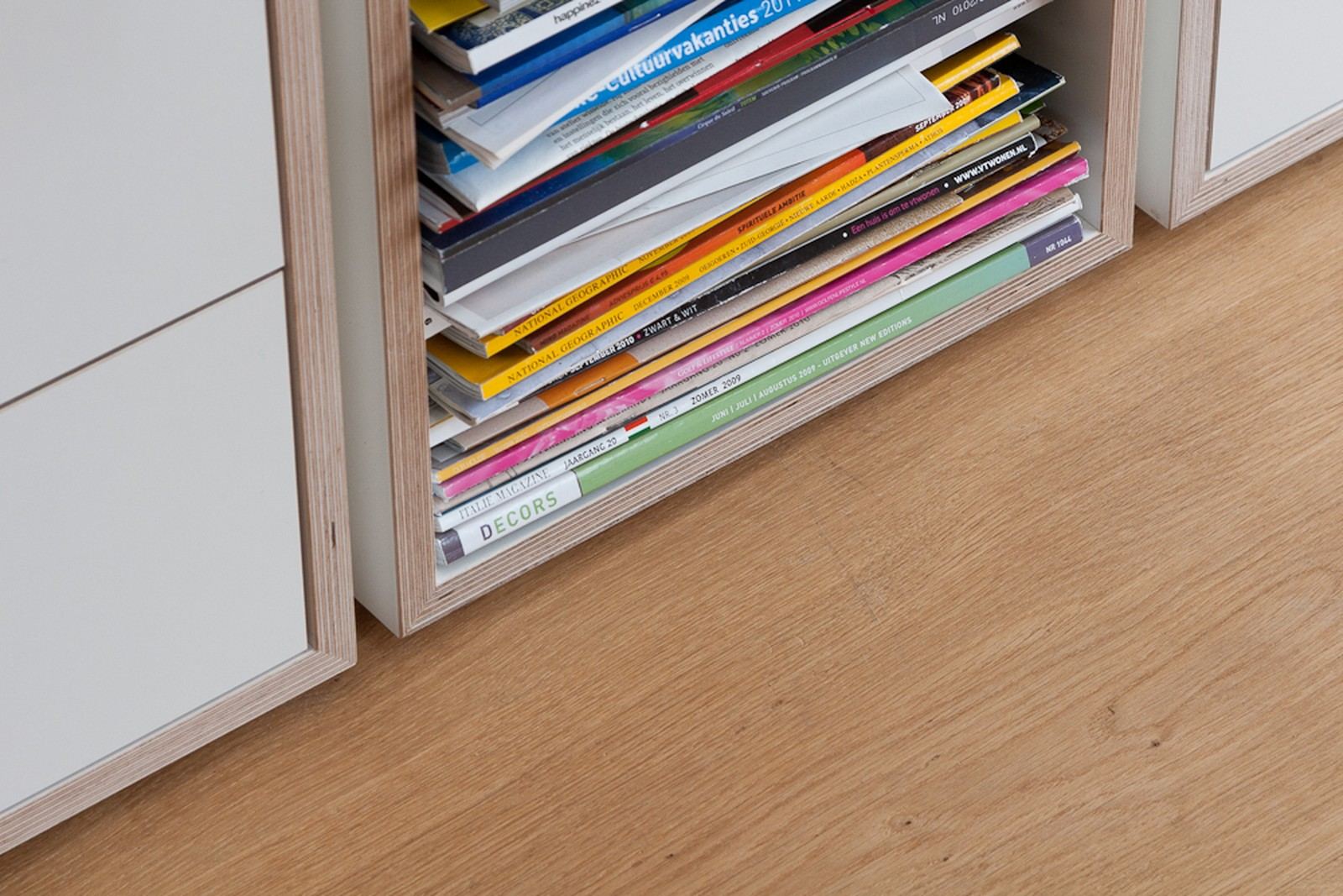 Detail van een vak vol tijdschriften onderin de boekenkast.