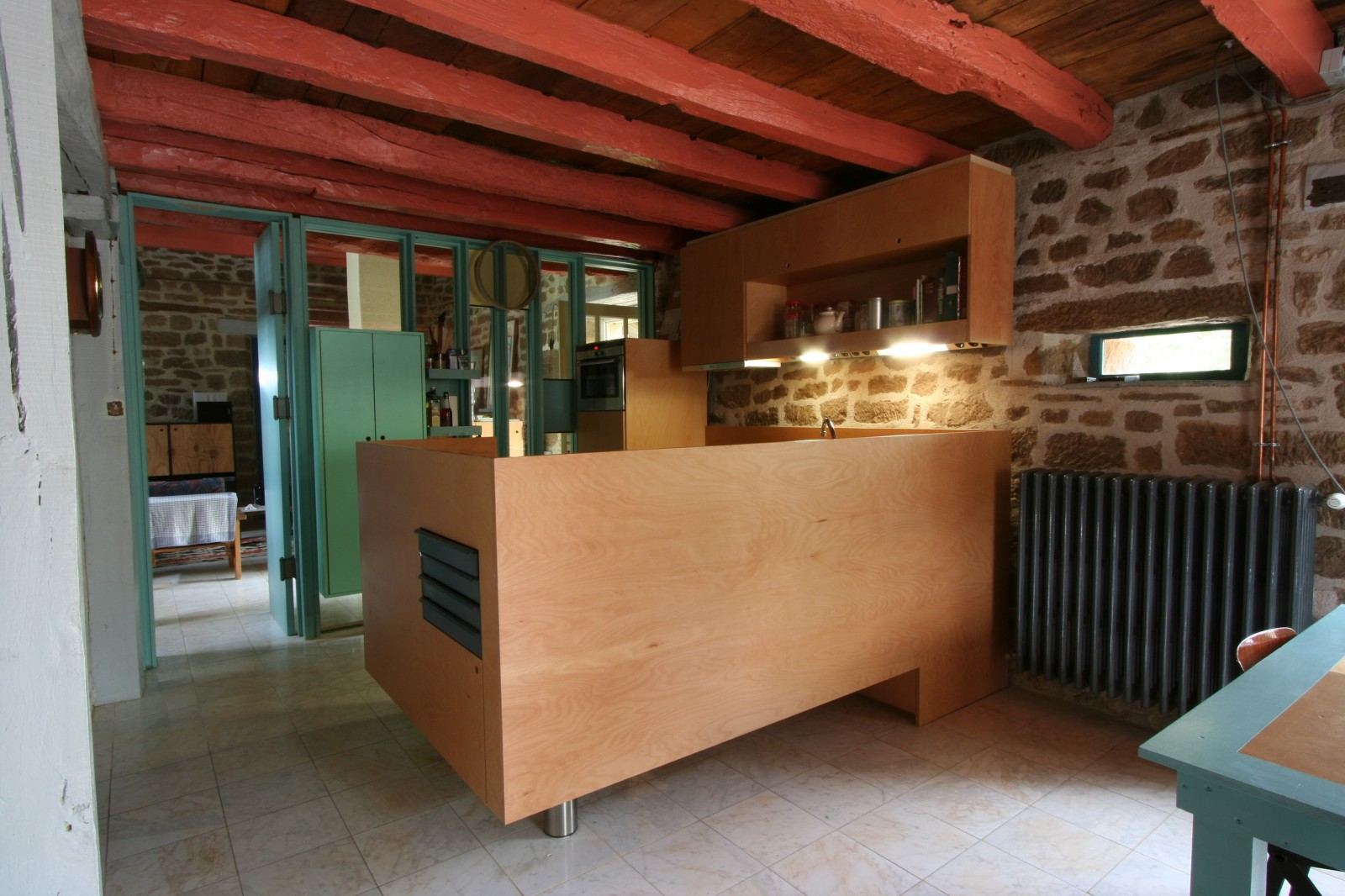 Zwevend keukeneiland op één ronde poot, met een ventilatierooster in het zijpaneel.