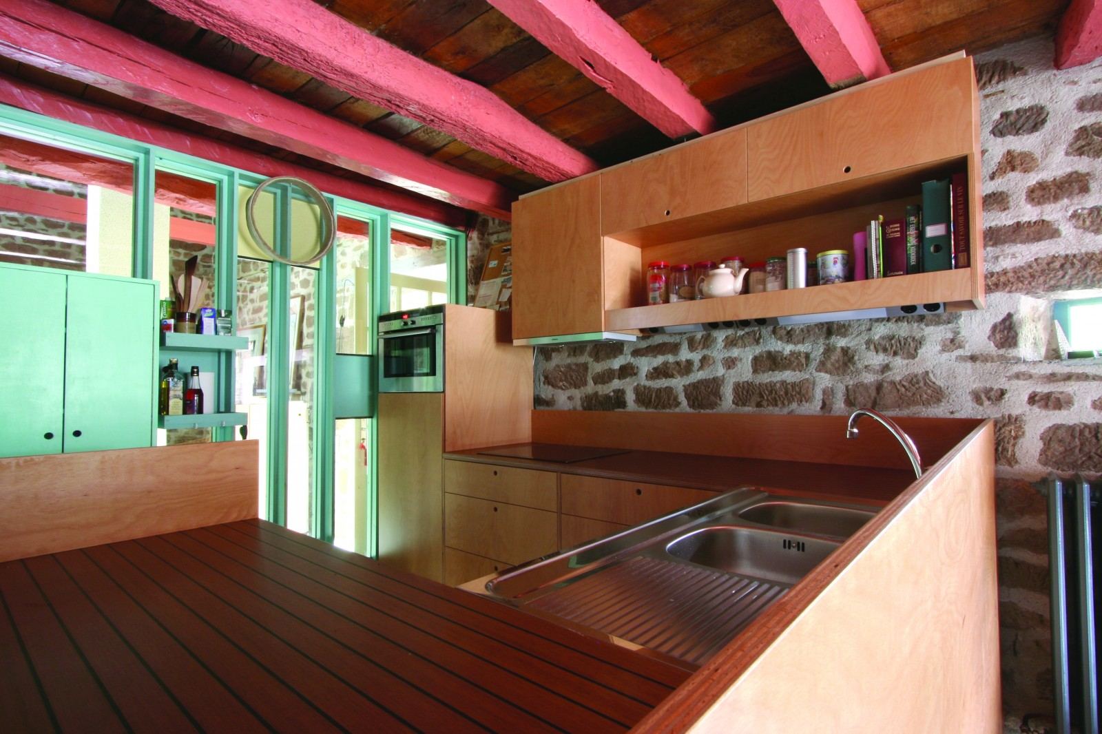 Houten keuken met een wandkastje met open vak, boven een geribbeld houten werkblad.