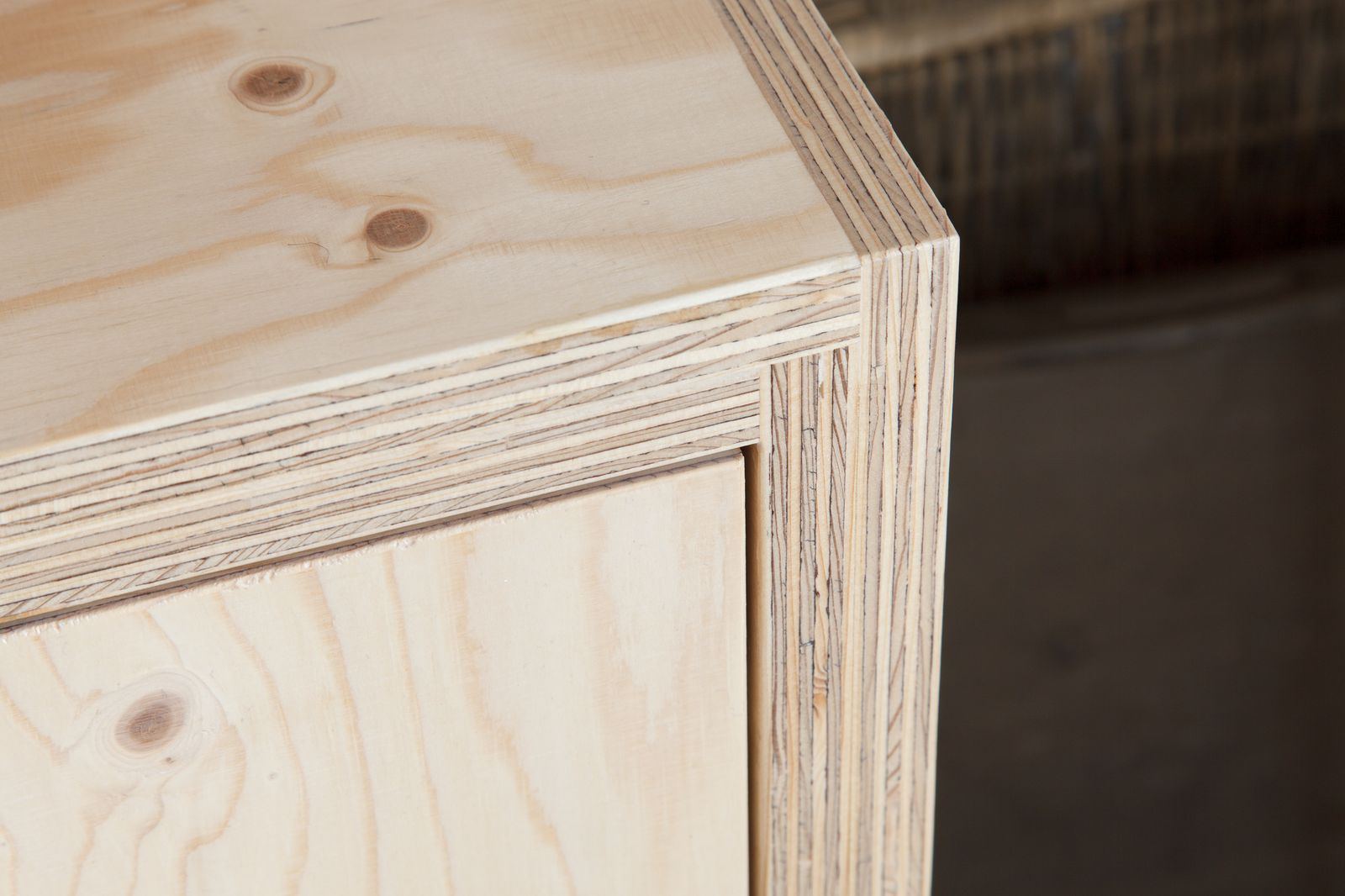 Detail van de hoek van een houten kast, boven een kastdeur.
