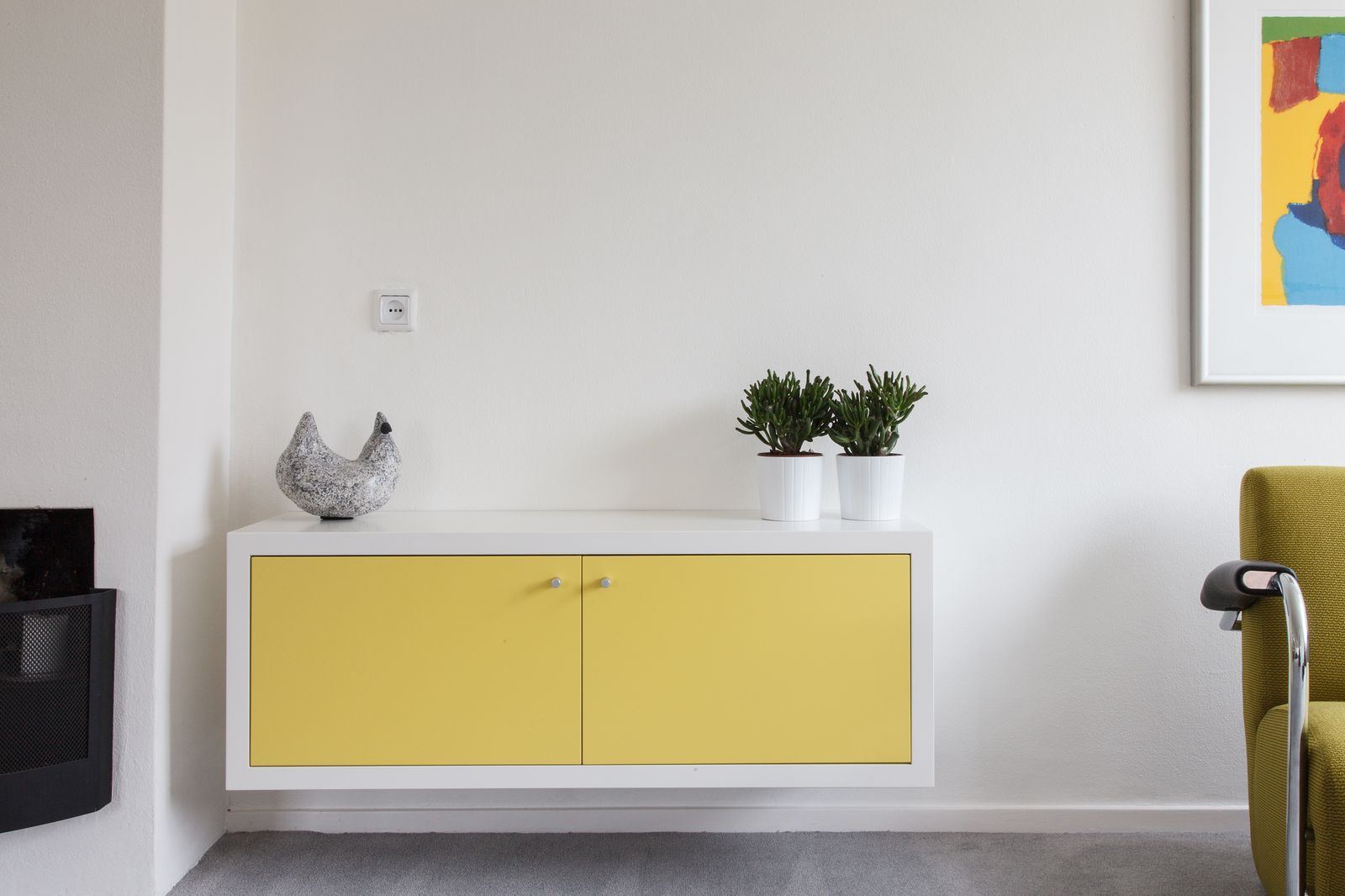 Kort zwevend dressoir met twee gele deuren en een wit kader.