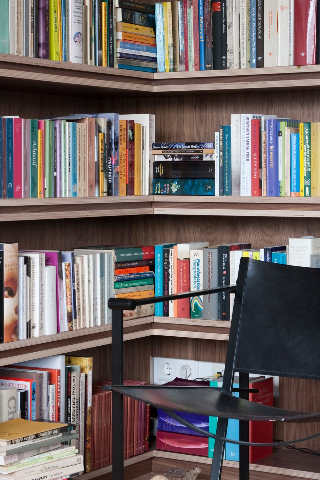Detail van de hoek van de boekenkast, waar twee wanden vol boeken samenkomen.