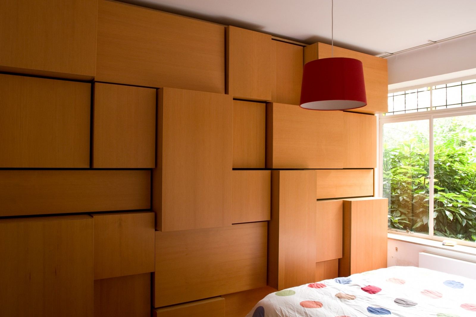 Kastenwand met deuren in verschillende groottes, van vloer tot plafond.