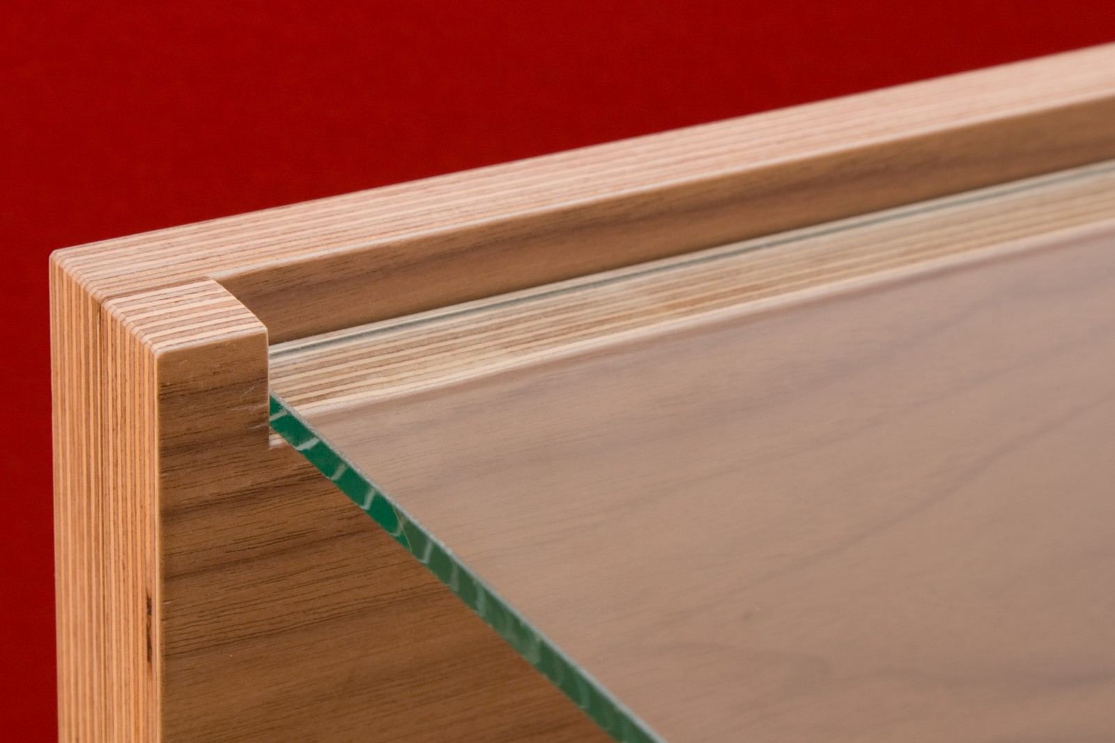 Detail van het glazen tussenblad in de kersen fineer module.