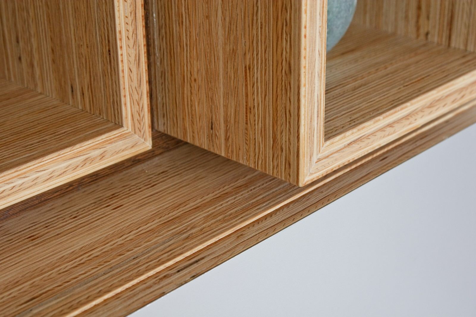 Detail van de plexwood hoekverbindingen tussen de open vakken.