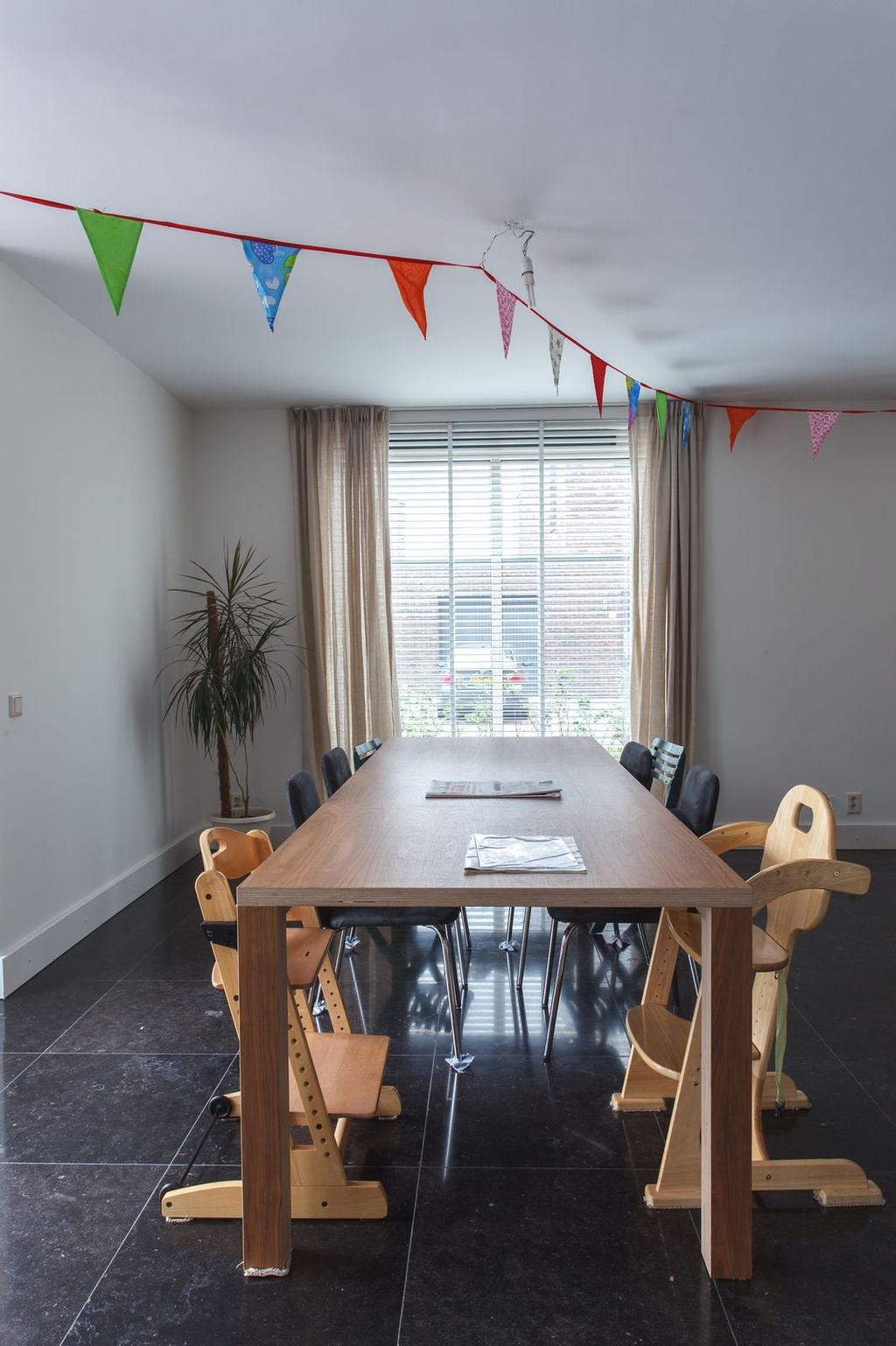 Eettafel van noten fineer op een houten onderstel.