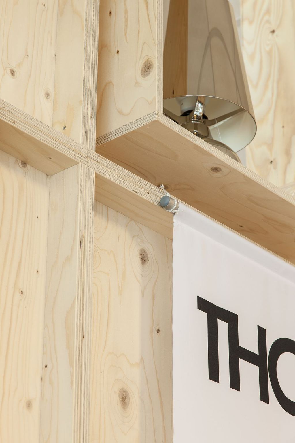 Detail van een houten planklegger met een kleine hanglamp eronder gemonteerd.