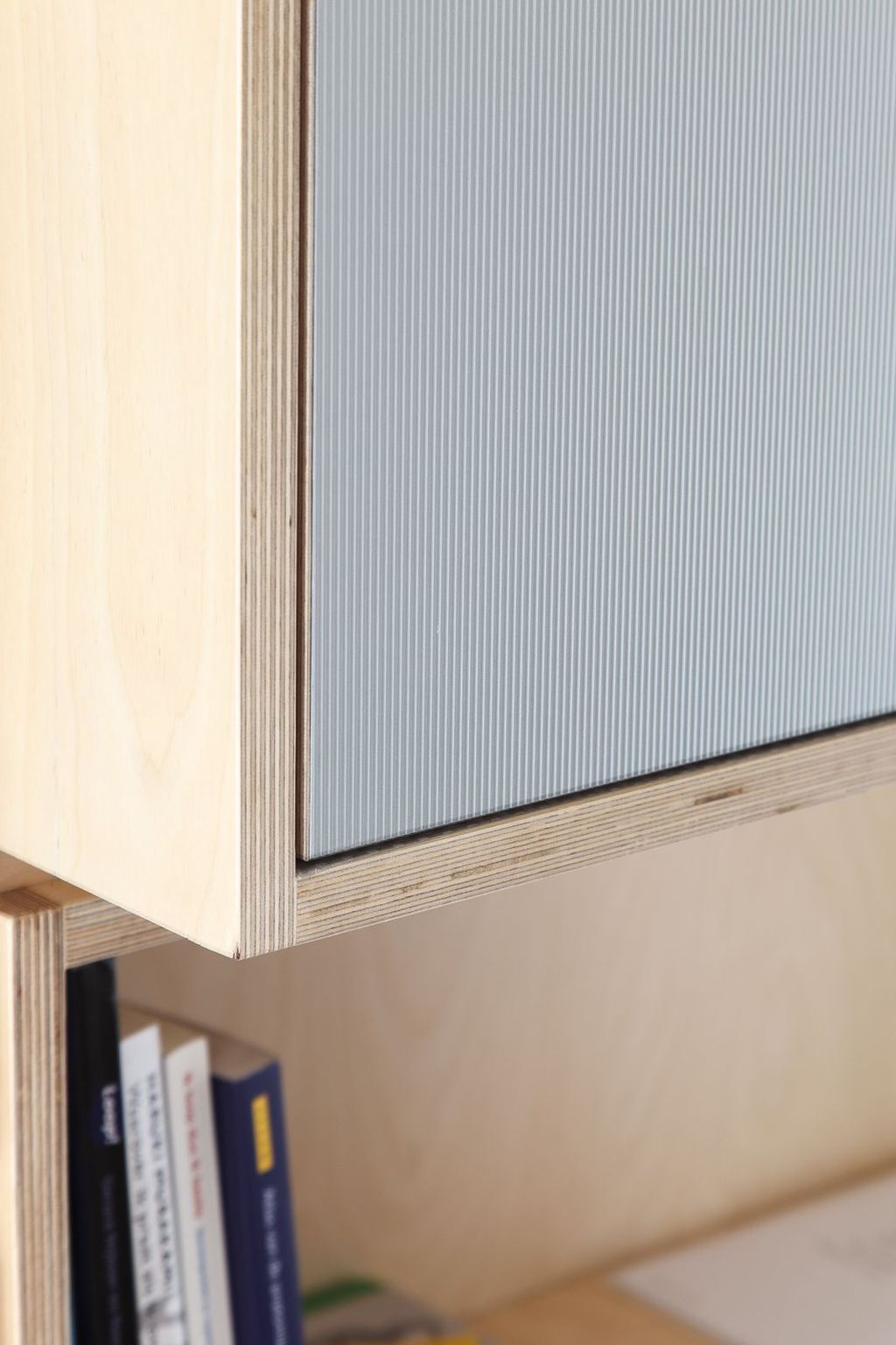 Detail van een kastdeur met geribbeld aluminium oppervlak.