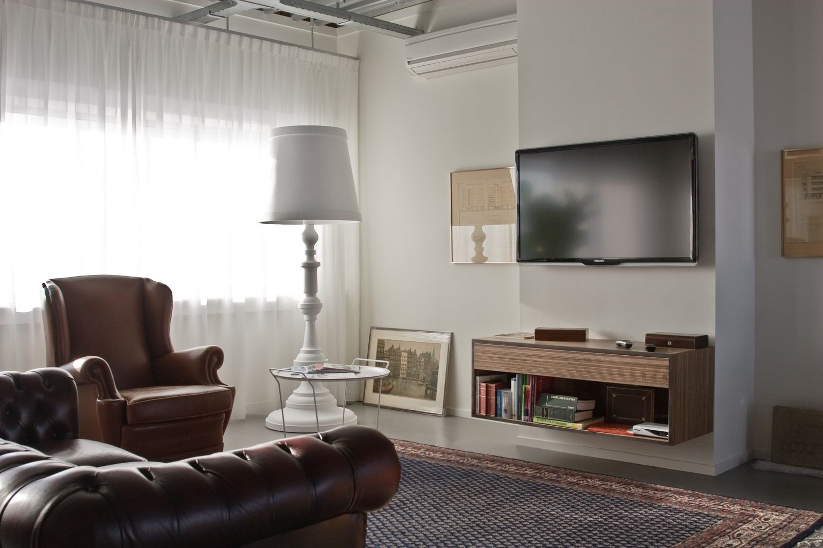 Zwevend tv-meubel met gesloten bovenkast en open boekenvak eronder.