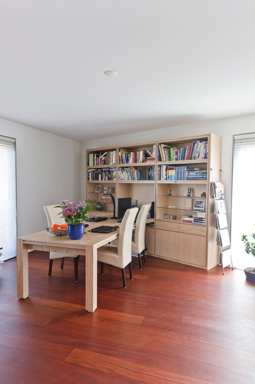 Boekenkast in eikenfineer met geïntegreerd bureau in de hoek.