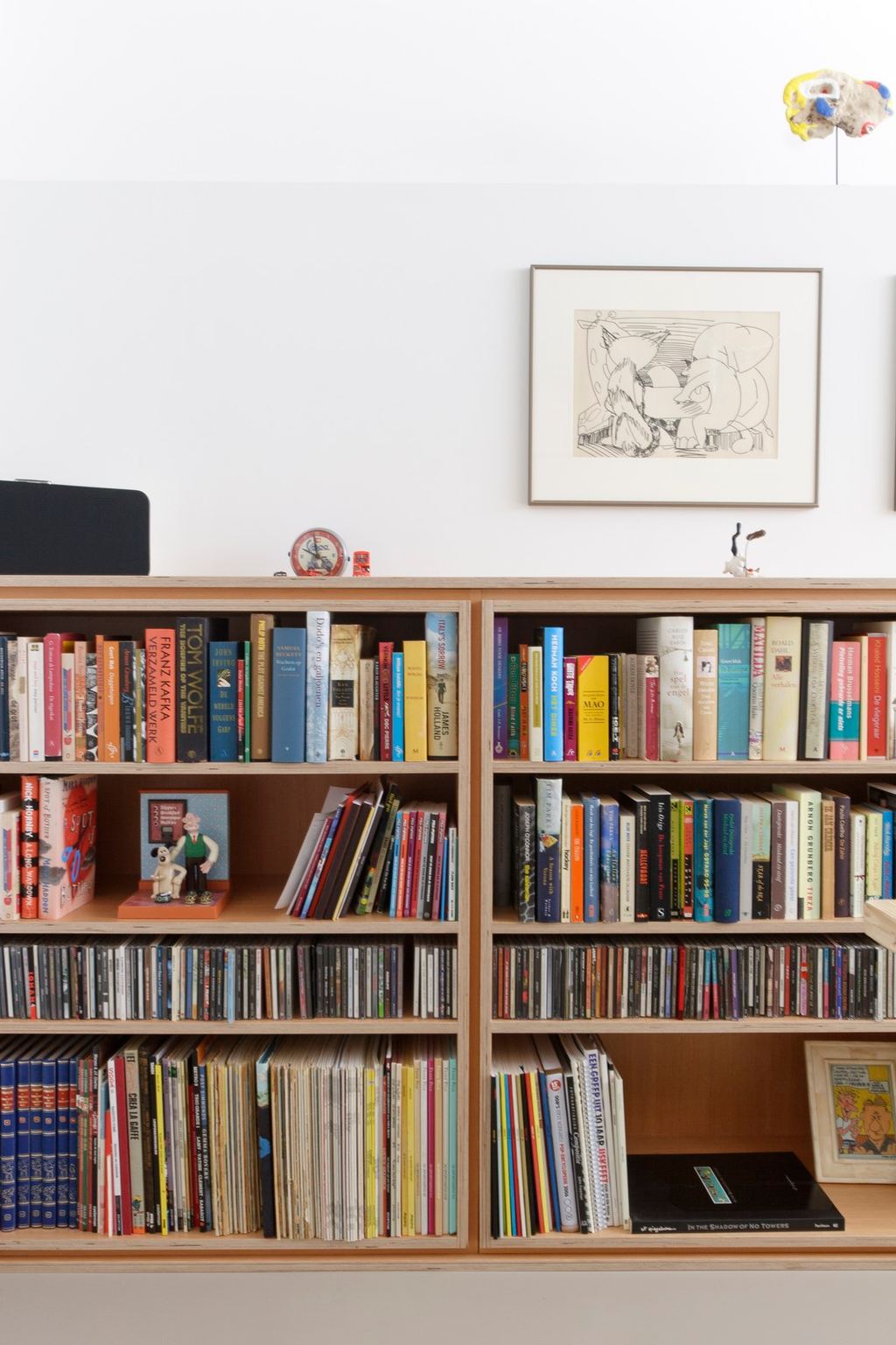 Lage boekenkast met vakken vol boeken, cd's en platen.