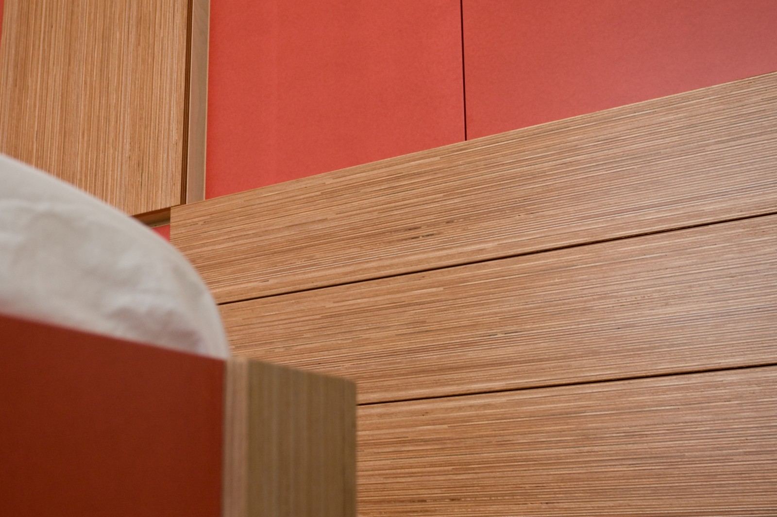 Close-up van de rand tussen een rood vlak en plexwood laden.