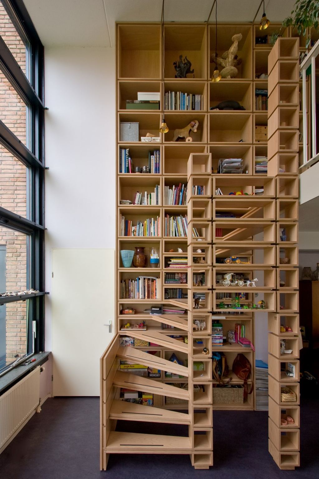 Boekenkast en trap van beuken multiplex die in elkaar overlopen.