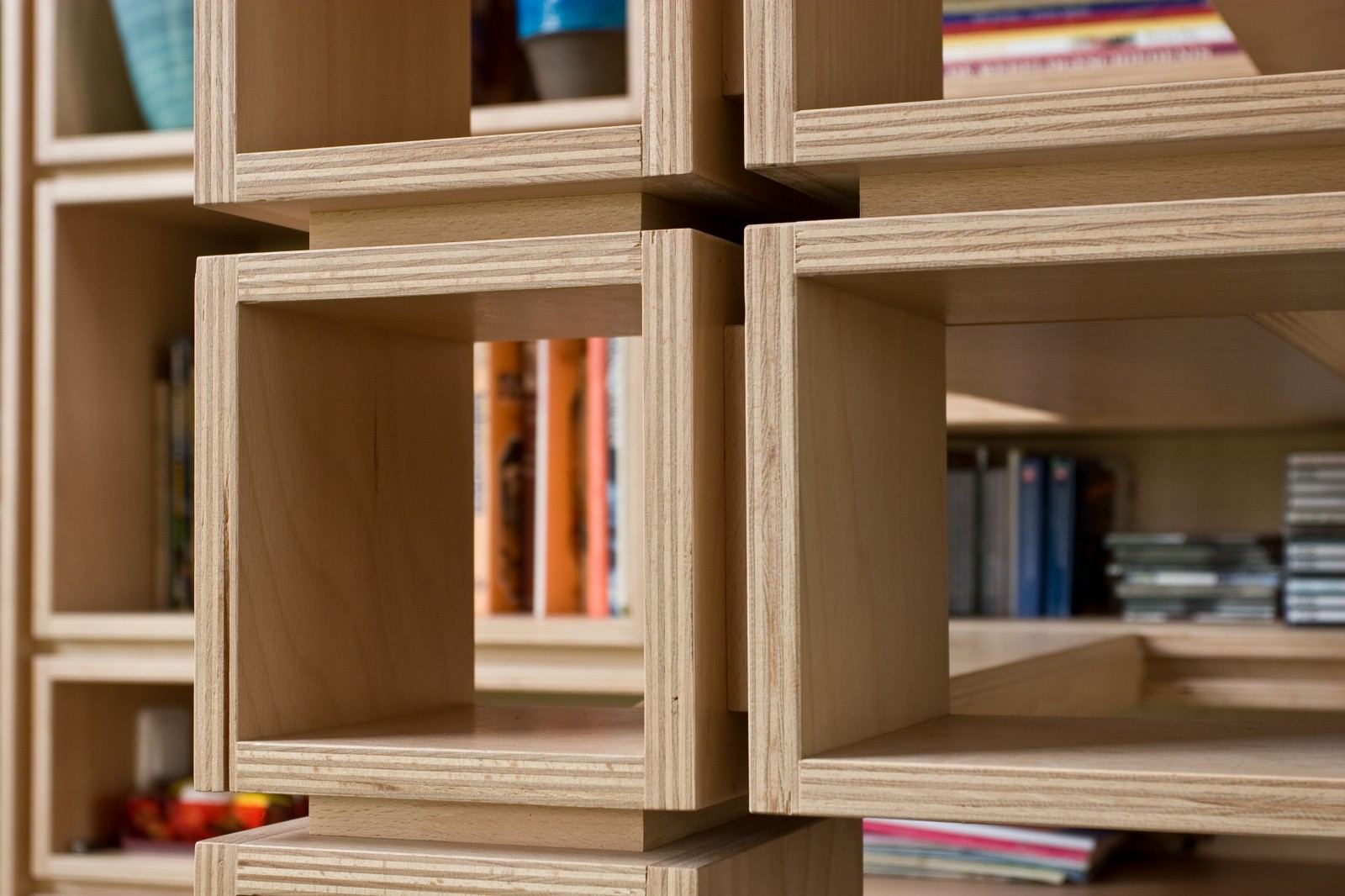 Kruisverbinding van vakken met cd's, boeken en een vaas.