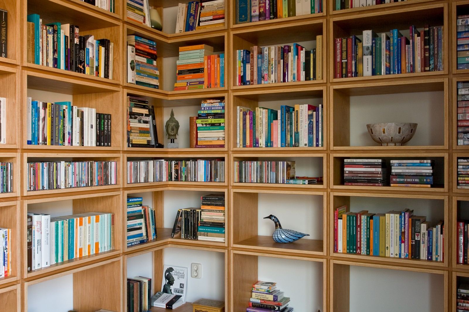 Detail van de vakkenkast met boeken en decoratieve objecten.